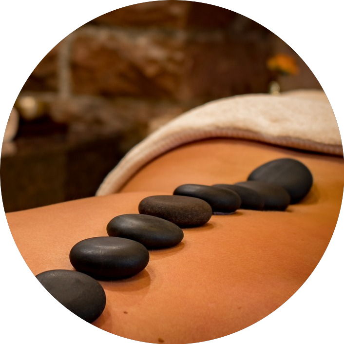 Heated black stones lined down a man's back during a hot stone massage.